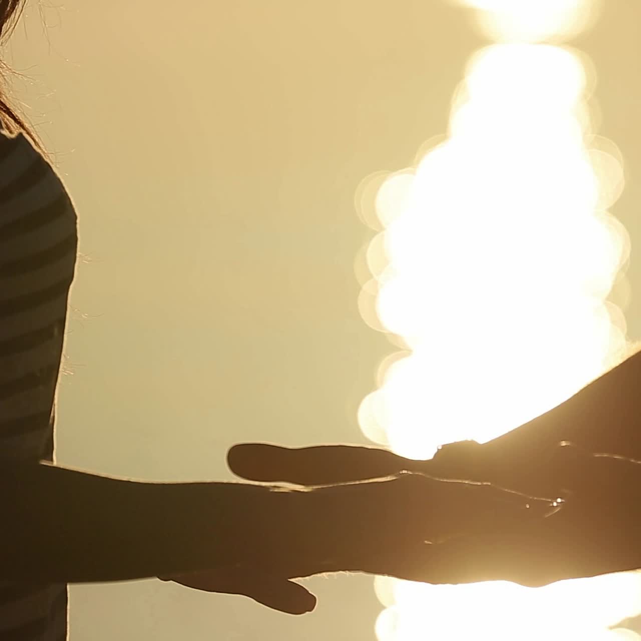 Hands couple against sunset