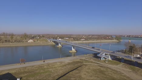 drone pull back from a bridge with moving vehicles