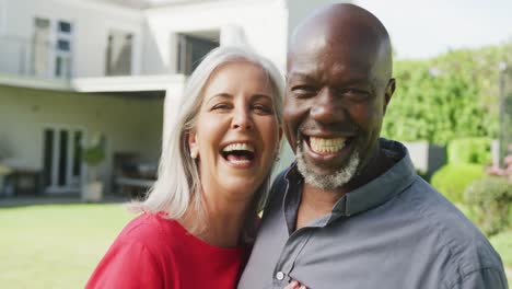 Portrait-of-happy-senior-diverse-couple-in-garden
