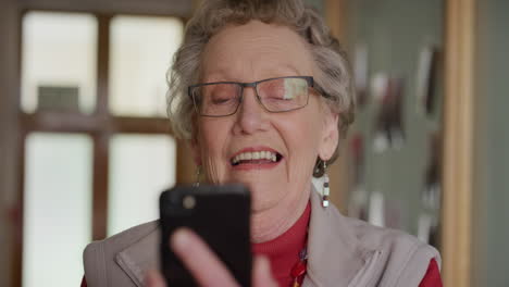 Porträt-Einer-Glücklichen-älteren-Kaukasischen-Frau,-Die-Im-Altersheim-Ihr-Smartphone-Nutzt,-Um-SMS-Zu-Schreiben-Und-Nachrichten-Auf-Der-Handy-App-Zu-Lesen