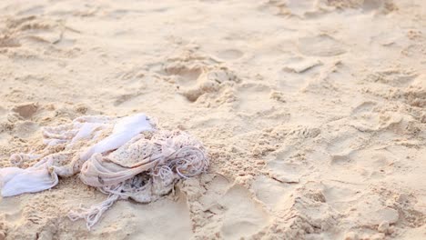 white cloth resting on sandy beach surface