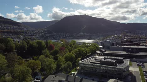 Bergen-mountain-Ulriken-and-big-lungegaardswater-with-buildings-in-front---Late-evening-slow-moving-reverse-aerial