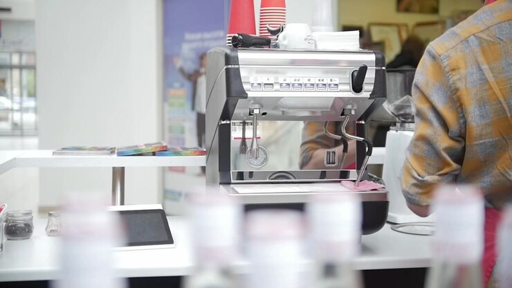 Barista wipes off a holder in a coffee shop