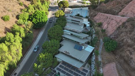 an aerial drone shot captures modern, terraced homes with multiple solar panels on a hillside in vicente paul, spain. this highlights a concept of sustainable architecture and urban living