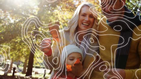 topography against caucasian family holding autumn leaves in the park