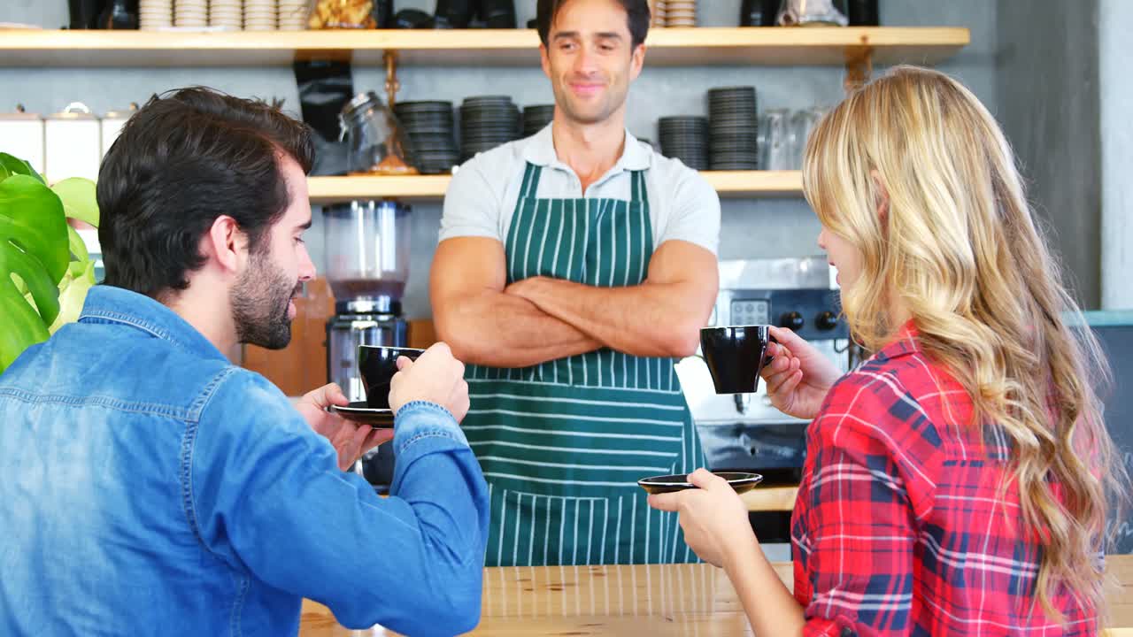 Junge Leute trinken Kaffee an der Theke vor einem Kellner