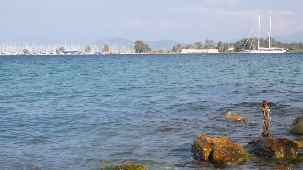 Sailboat and Cleopatra marina in the background seen from Kiani Akti beach, Preveza, Greece