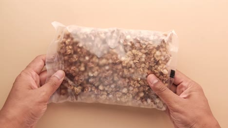 manos sosteniendo una bolsa de granola