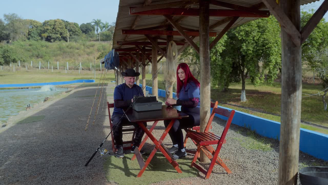 People Preparing Fishing Gear by a Pond
