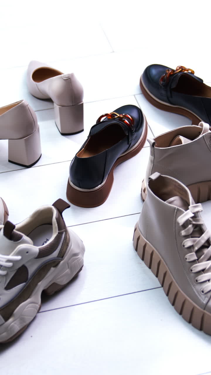 Diverse footwear put in circle on the white floor. Modern fashionable shoes for different occasions. Close up. Vertical video