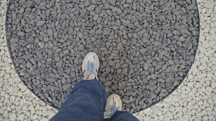 man walking on black and white stones
