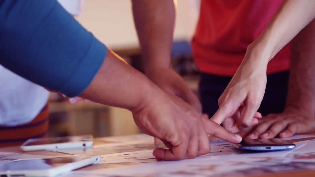 업무 동료 들 이 사무실 에서 문서 를 논의 하고 있다