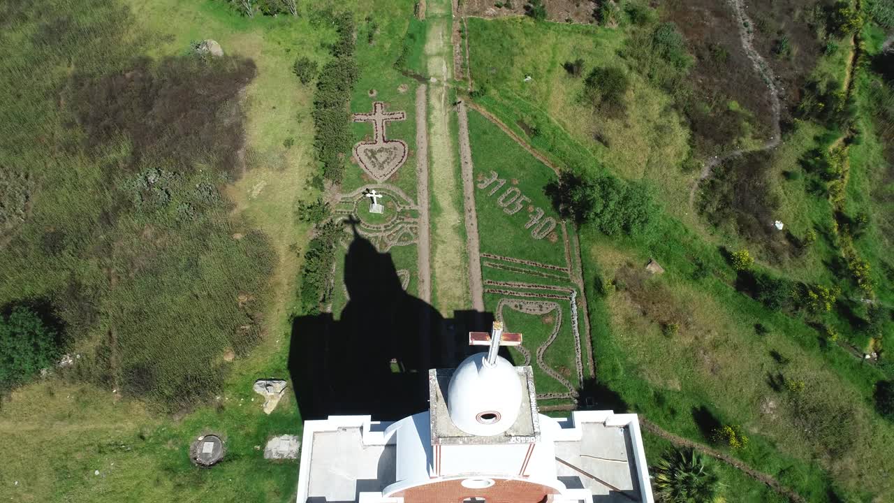 Detailed aerial view of the church at Yungay Cemetery, Áncash, Peru. The shot captures religious symbols and the serene memorial site honoring the 1970 earthquake victims, surrounded by lush greenery