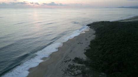 Aerial-of-sunset-at-isolated-tropical-sand-dunes-wild-beach-in-Oaxaca-Puerto-Escondido-Mexico