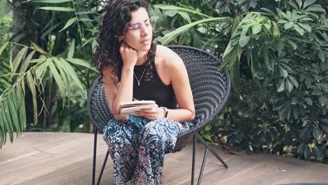 Beautiful-woman-sitting-and-writing-down-ideas-into-notebook