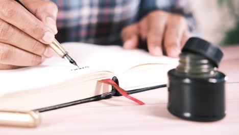 persona escribiendo en un cuaderno con un bolígrafo