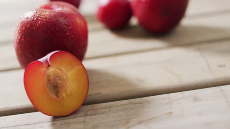 video of fresh plums lying on wooden surface