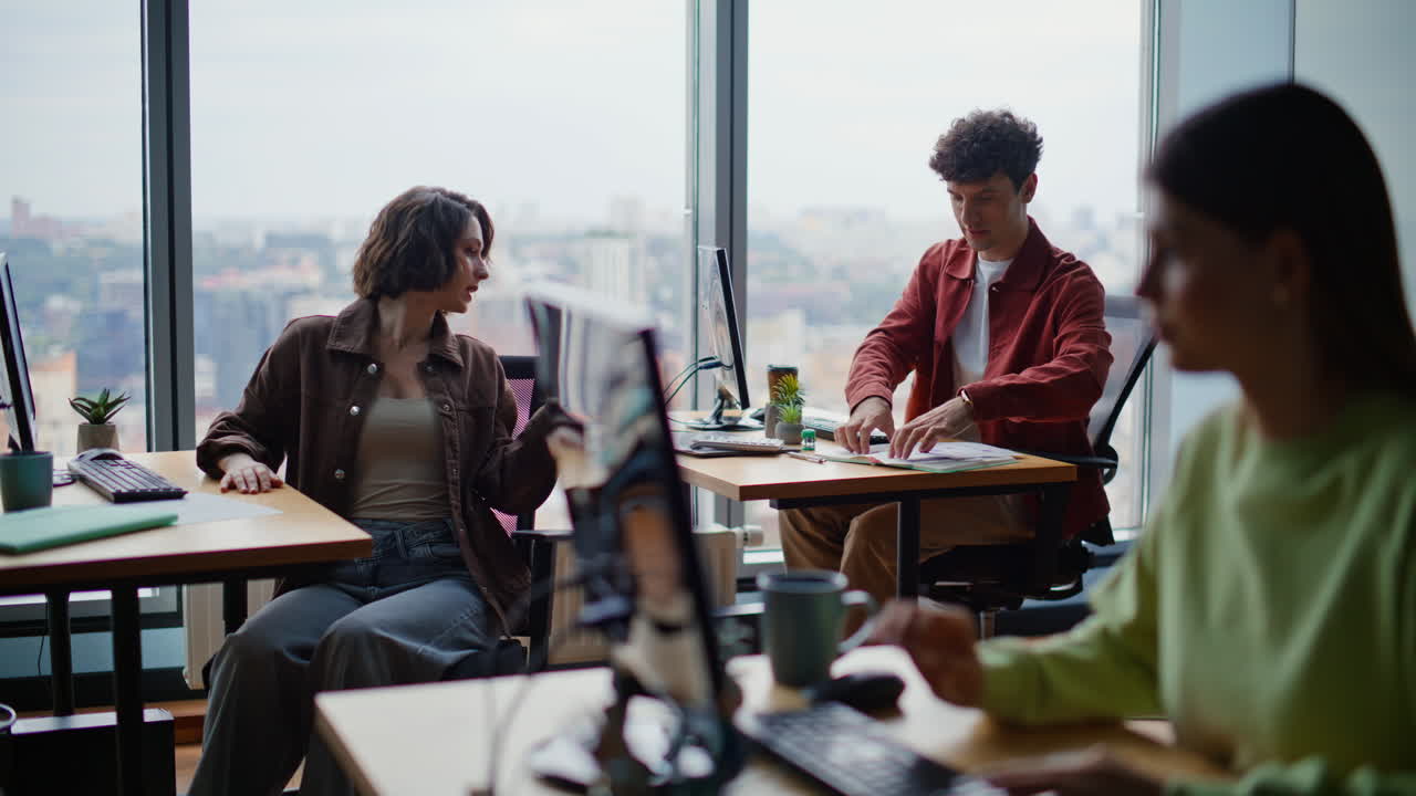 Young programmers coding computers sitting together at spacious coworking zone