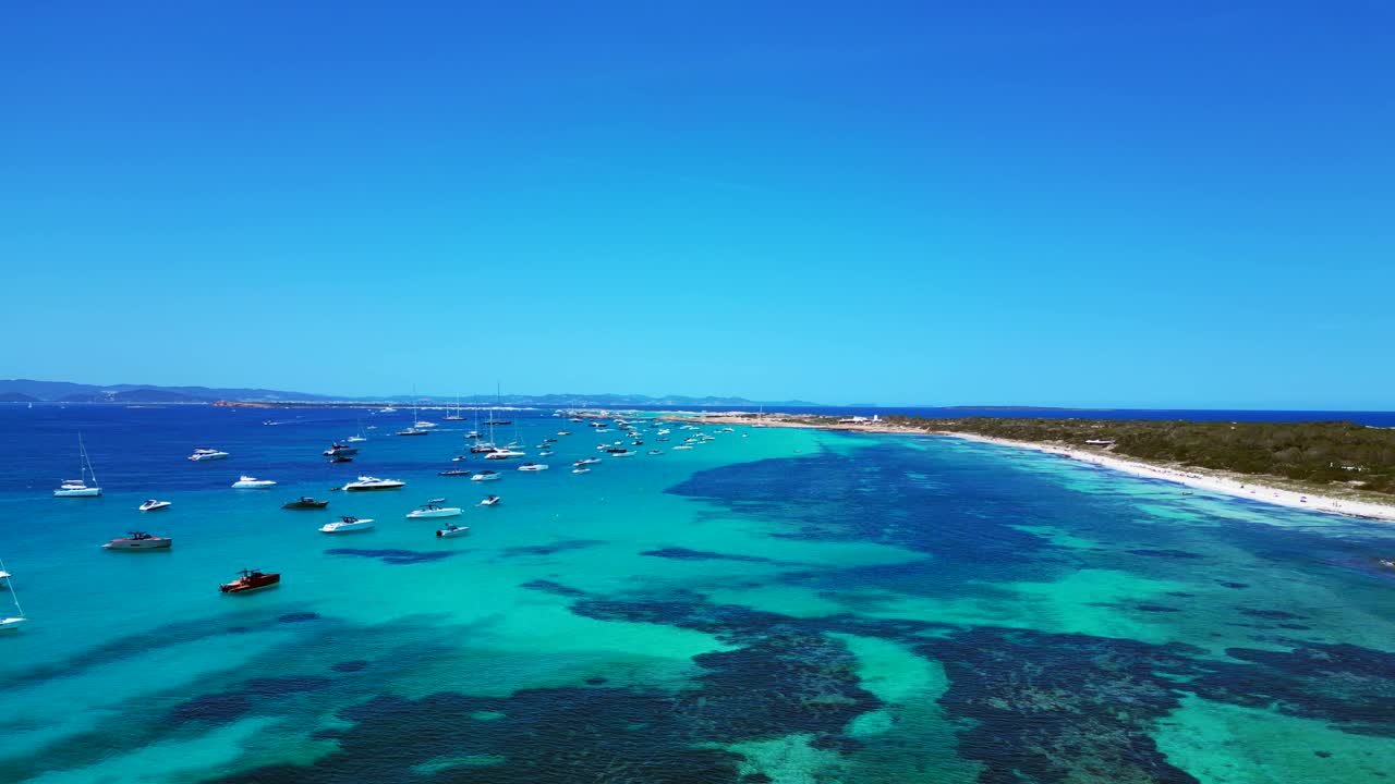 Barche ancorate nelle splendide acque turchesi cristalline di Formentera, una spiaggia di sabbia bianca con Posidonia oceanica. Incantevole vista aerea, sorvolo, avvicinamento, drone
