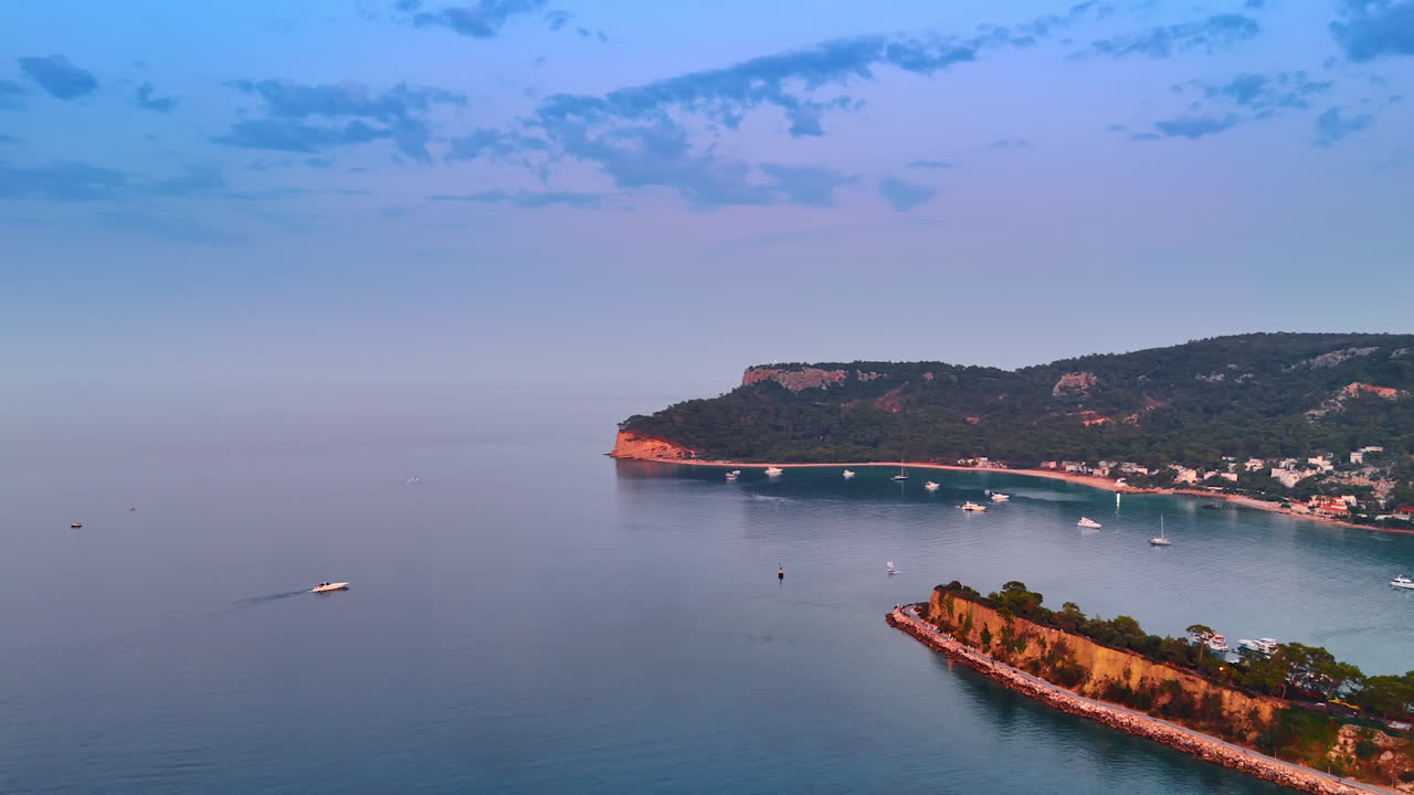 Beautiful coast of the Mediterranean Sea in Turkey at sunset time. Drone footage over the waterscape with some yachts on