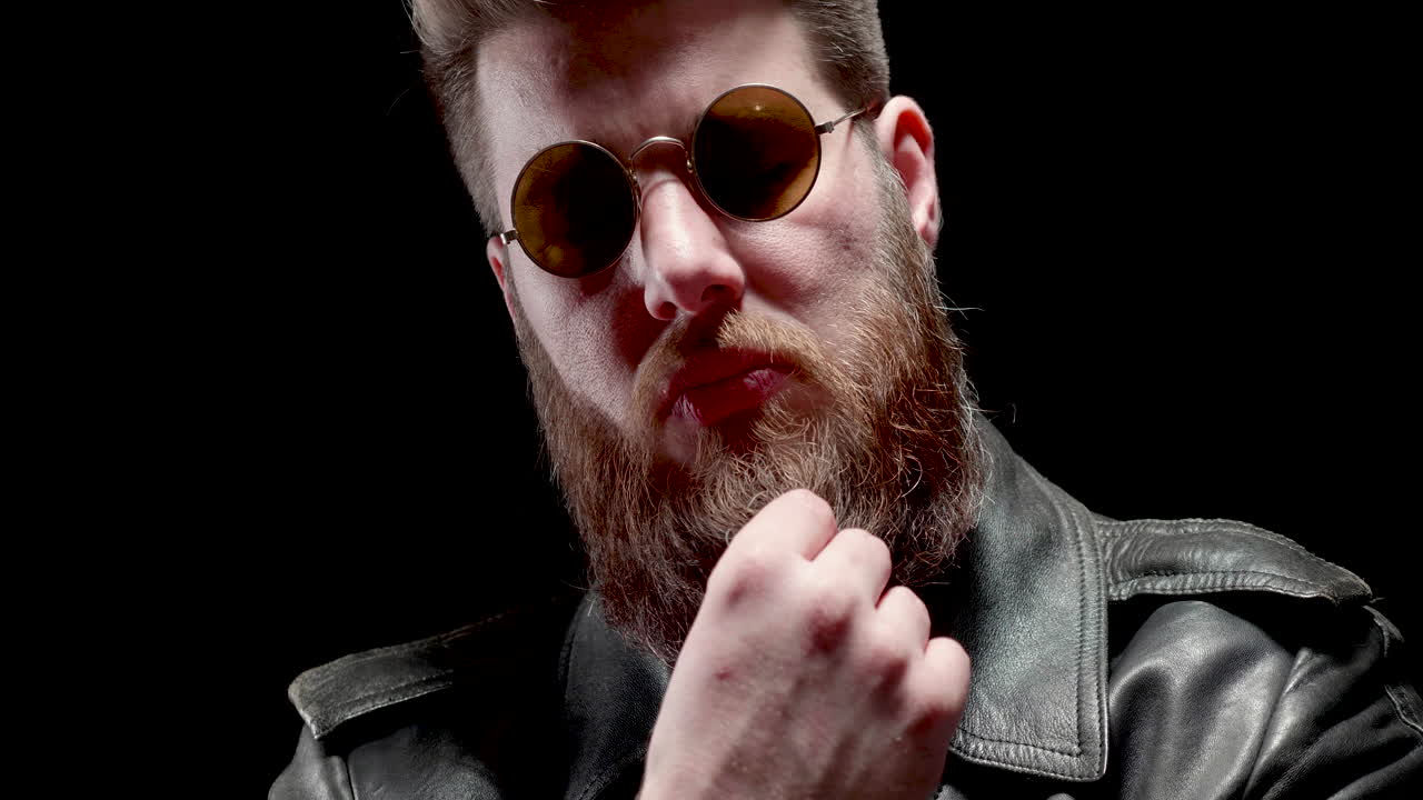 Man with beard and sunglasses in leather jacket