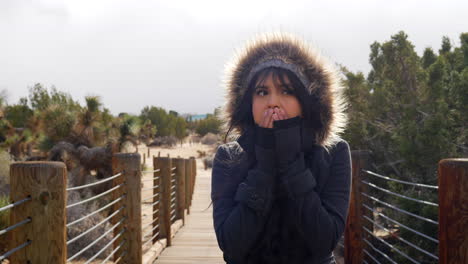 Attractive-young-woman-shivering-in-freezing-cold,-stormy-bad-winter-weather-with-rain-drops-under-cloudy-sky-SLOW-MOTION