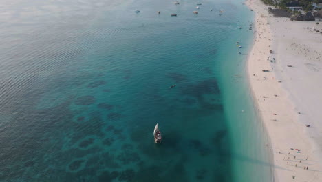 Vista-Aérea-De-Un-Barco-De-Madera-Navegando-Cerca-De-La-Maravillosa-Playa-De-Zanzíbar.