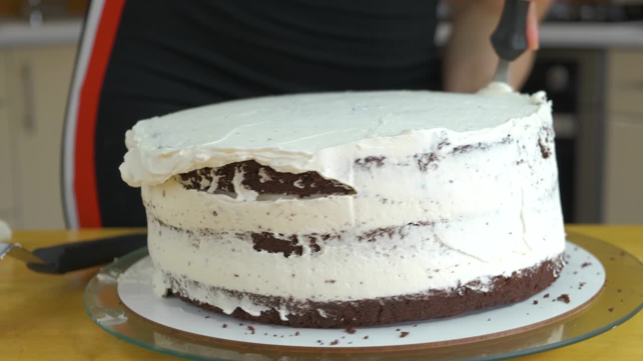 크림과 비스으로 달한 케이크를 만드는 여성 손의 클로즈업.