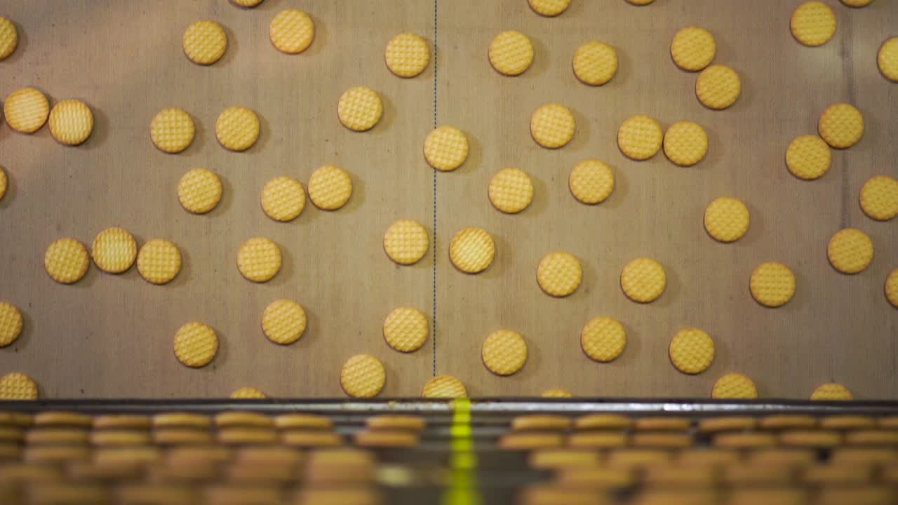 Overhead shot of baked biscuits in a conveyor belt of a factory
