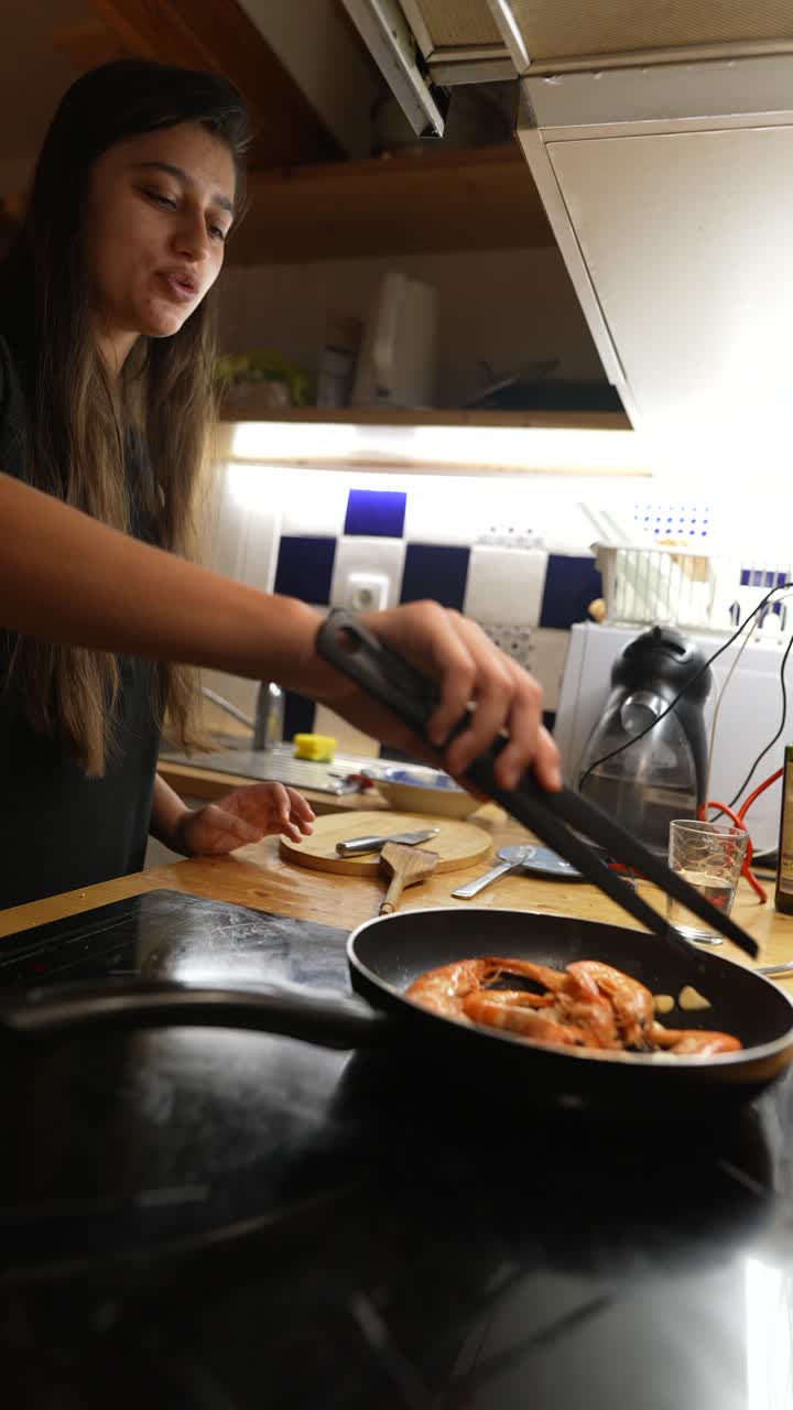 mujer cocinando camarón en una cocina