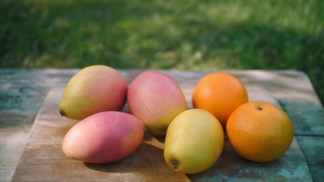 Frutta tropicale fresca disposta su un tagliere di legno all'aperto
