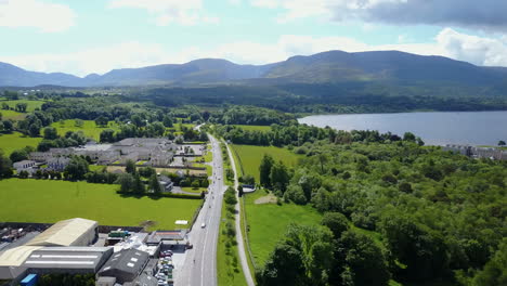 High-altitude-panning-aerial-video-of-Motor-bikers-traveling-along-a-beautiful-journey,-beside-the-Lakes-of-Killarney,along-"The-Ring-of-Kerry",-Ireland