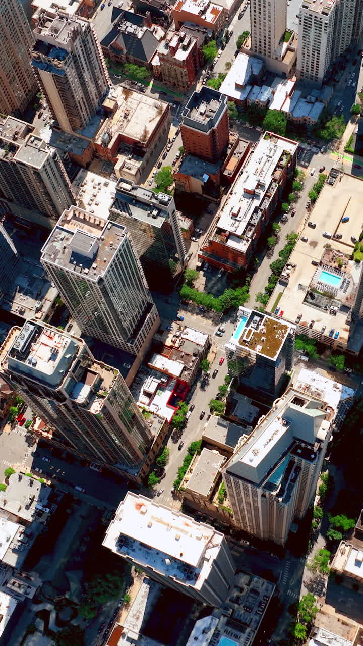 Vídeo vertical de paisagem urbana aérea de Chicago, EUA, com ruas da cidade, arranha-céus, telhados de casas, prédios comerciais e áreas externas.