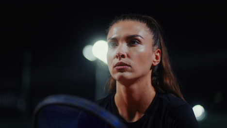 mujer concentrada en el juego de tenis nocturno