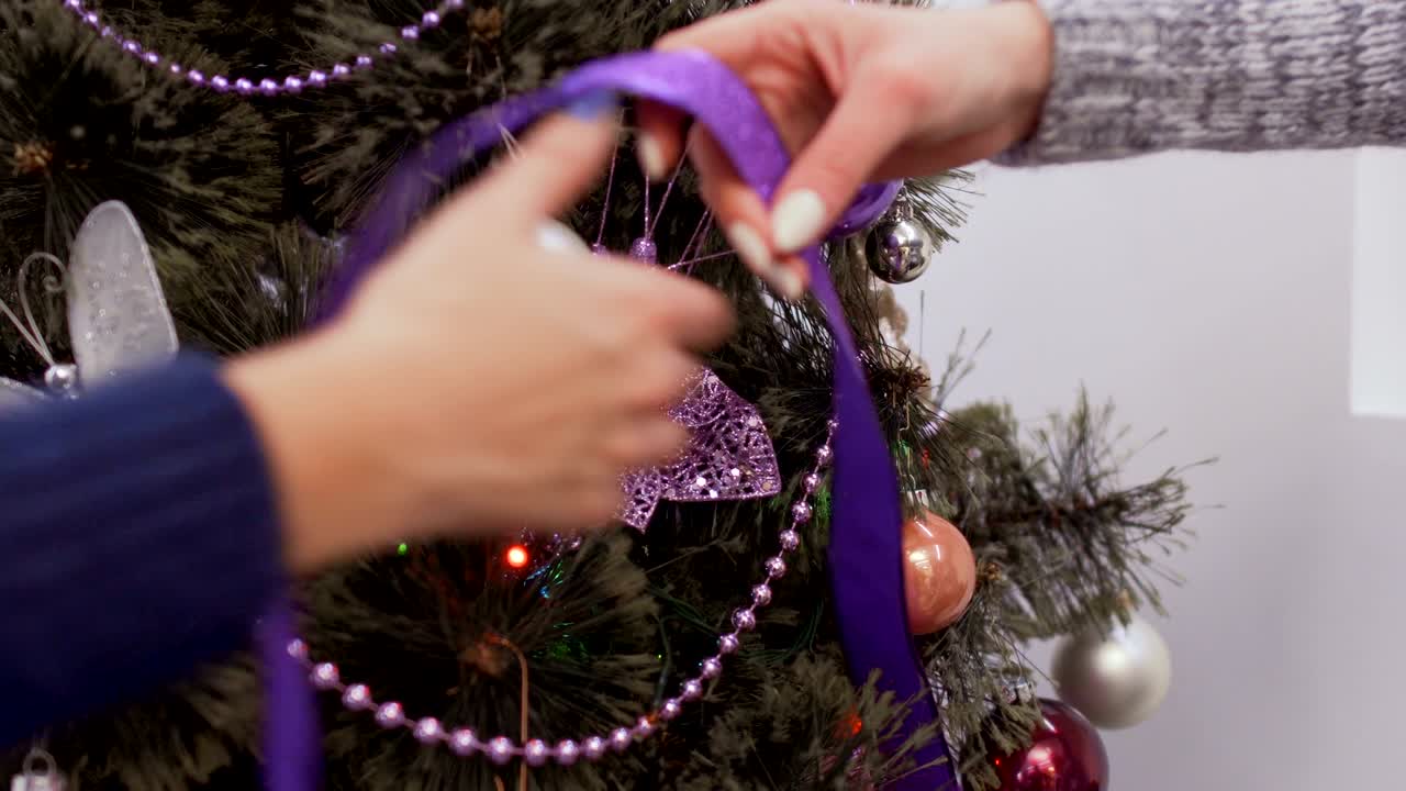 las chicas jóvenes decoran el árbol de navidad.