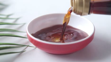 soy sauce pouring into small bowl