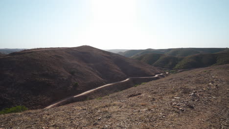 small valley between barren and dry hills in algarve, portugal - slow push in