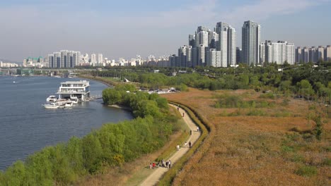 Vista-Desde-El-Puente-Dongjak-En-El-Río-Han-Y-Gente-Caminando-En-El-Parque-Del-Río-Han