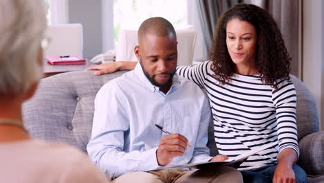 happy couple taking financial advice signing a document