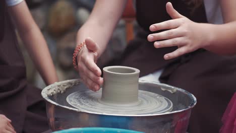 grandmother with a grandchildren make pitchers in pottery