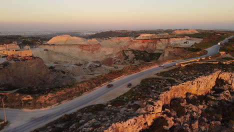 sunset drone shot of suv by the rocks