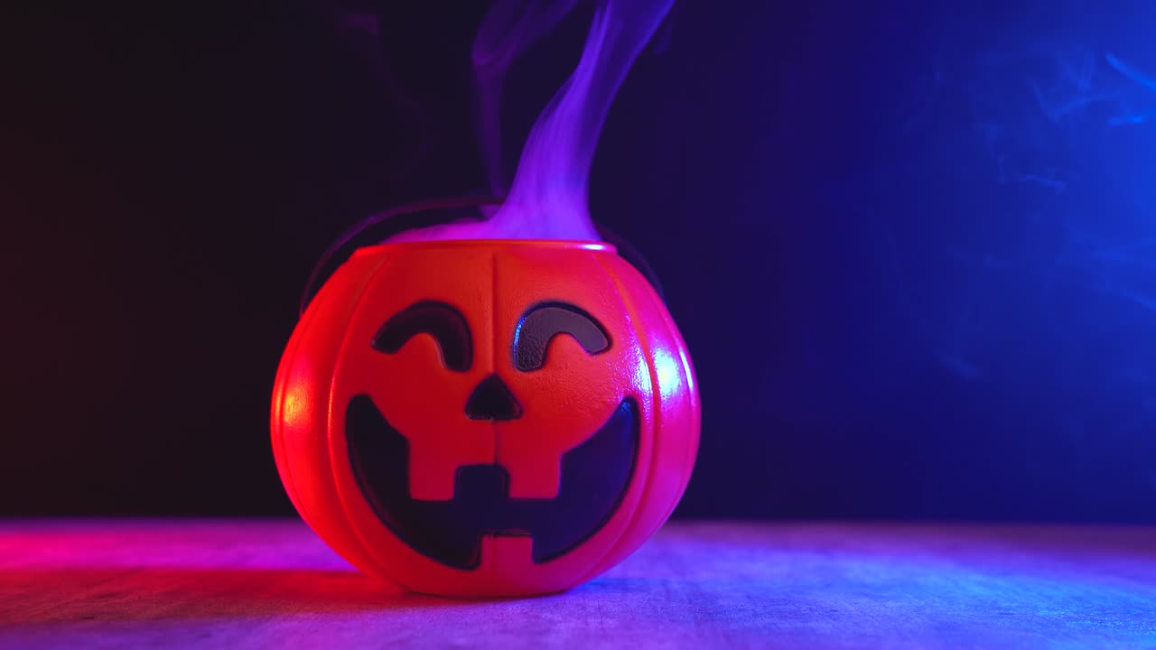 juguete calabaza de halloween fumando desde adentro en la mesa, en fondo oscuro con luces de neón