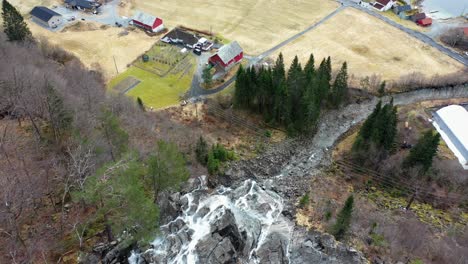 Antena-Desde-La-Cascada-Kvernhusfossen,-Inclinada-Hacia-Arriba-Revelando-Mo-En-Modalen-Noruega