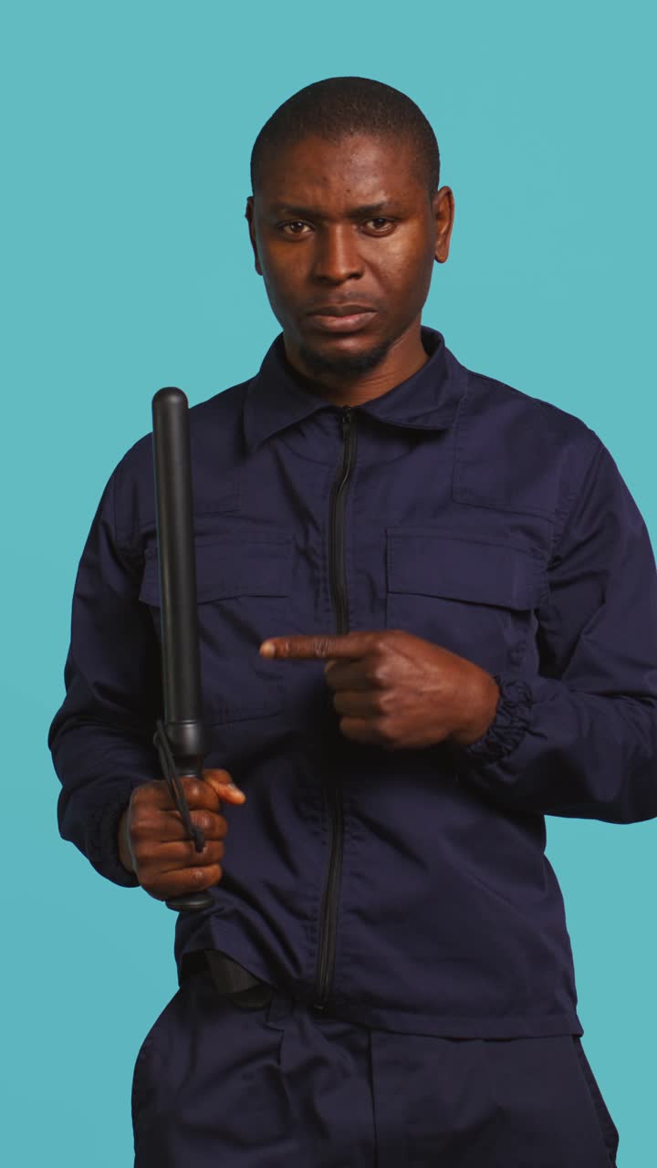 Serious Police Officer Pulls Out and Points to Baton