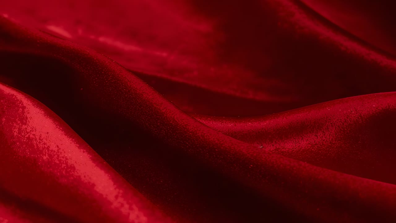 Camera starting close view rich red velvet fabric in studio, capturing slow wave-like undulations