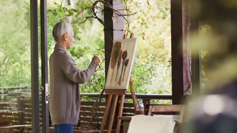 mujer de raza mixta de alto nivel pintando en el balcón