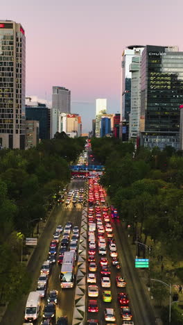 vertical drone shot over traffic on the reforma avenue, dusk in mexico city