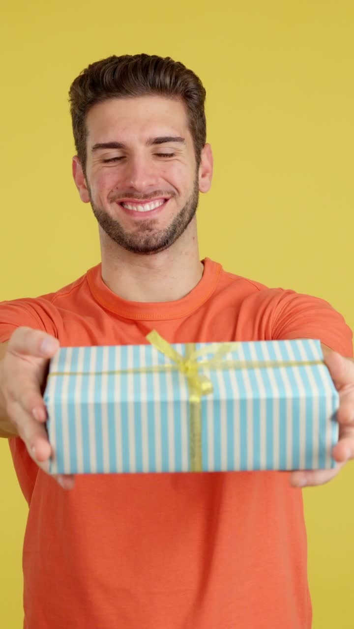 Happy Young Man Presenting a Gift Box
