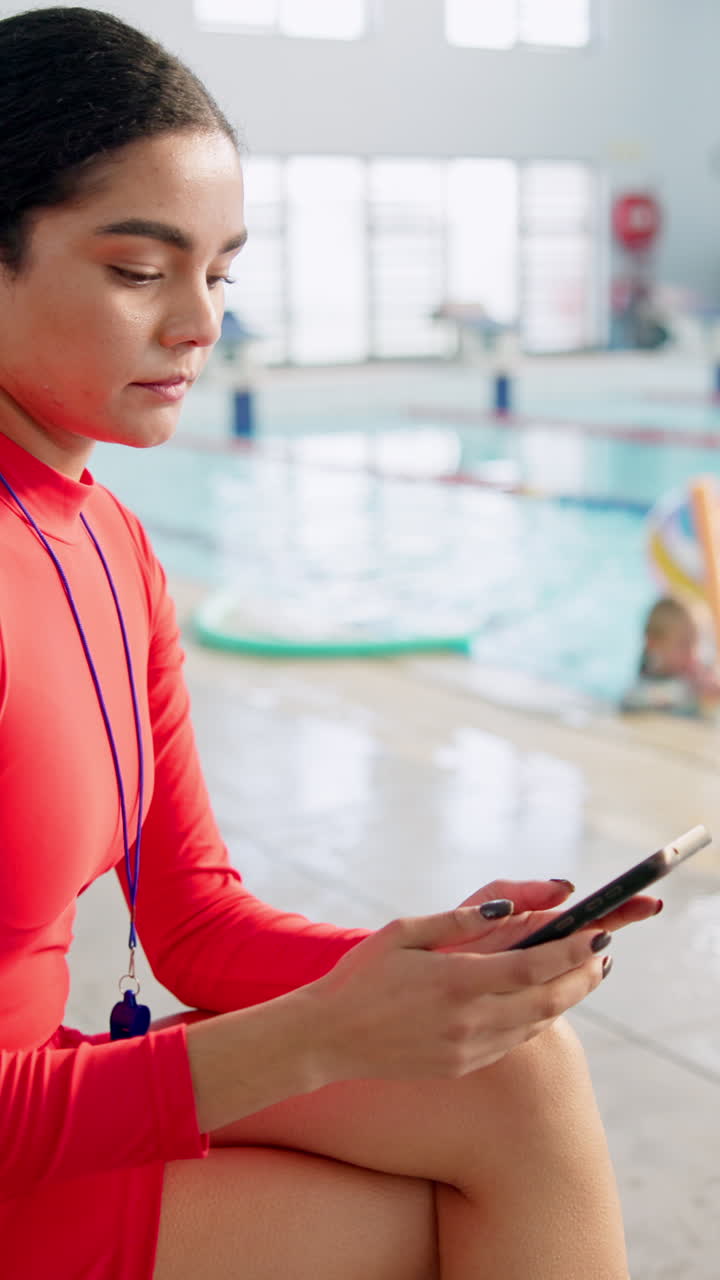 socorrista usando el teléfono junto a la piscina con niños