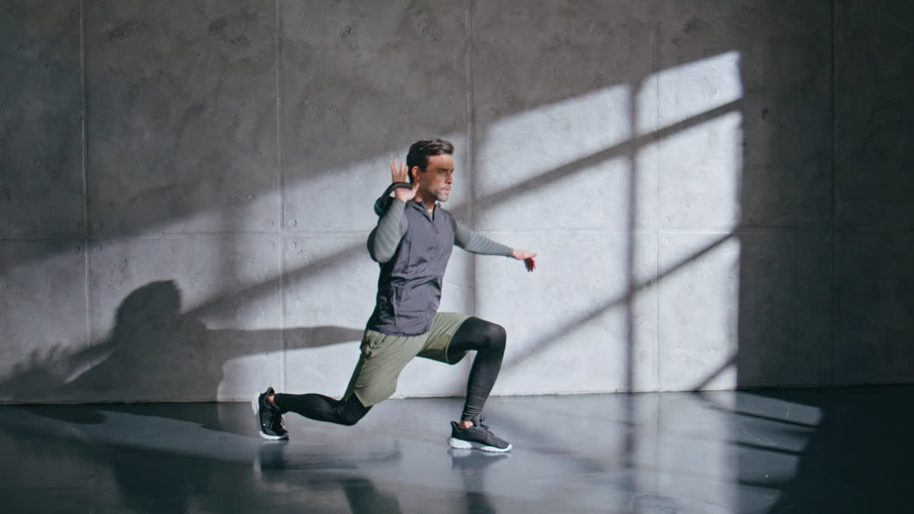 Lunges man holding kettlebell at indoor health club. Guy enjoying muscle sport